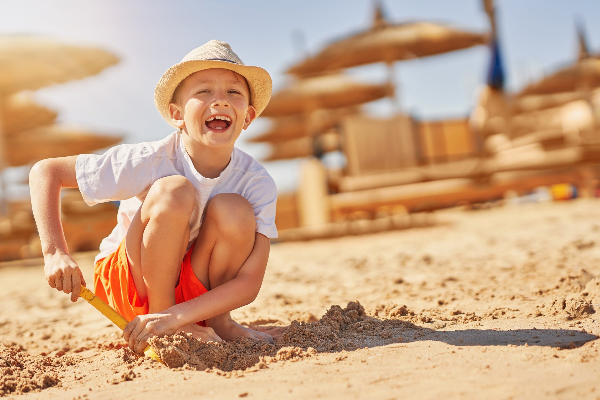 image-of-a-young-boy-playing-with-sand-on-the-beac-2023-11-27-05-37-25-utc